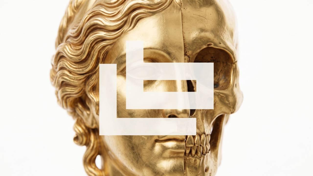 Gold bust — half sculpted face, half skull — under the white letbe mark